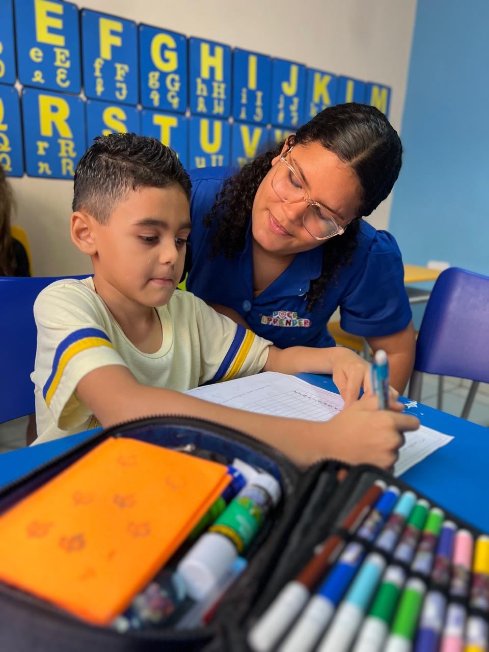 Educadora do Doce Aprender acompanhando criança em uma atividade pedagógica